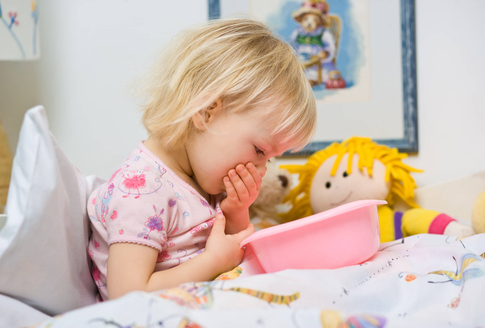 little sick girl in bed with bowl