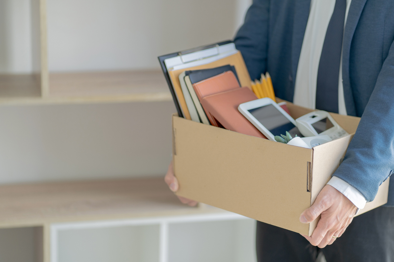 Stressful businessman packing a box for quit a job.