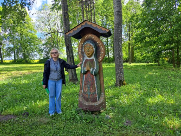 cb31c0bd-06df-4c4f-bbf2-5fb296e1229b Etnografė Regina Lukminienė prie skulptūros Šventybrasčio Barborai