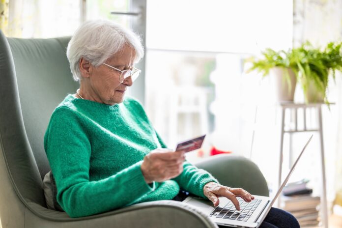 Senior,Woman,Using,Laptop,And,Credit,Card,For,Online,Shopping