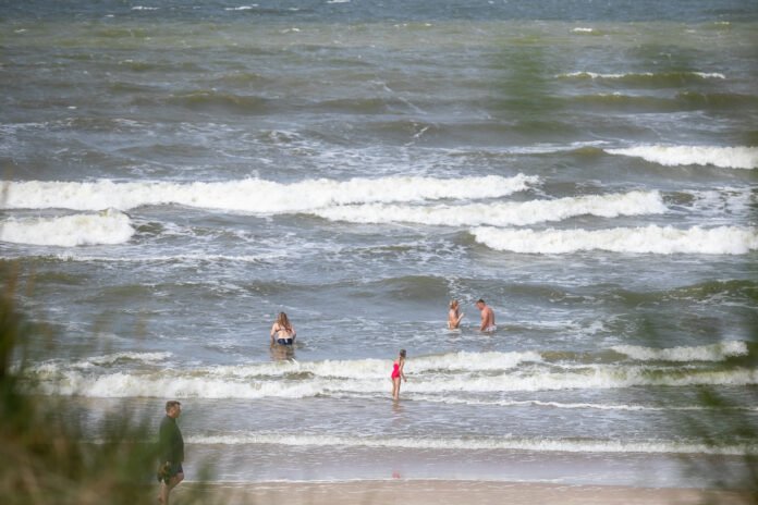 ELTA6560999 Šilti orai į Palangos paplūdimius sutraukė gausų būrį poilsiautojų. Žmonės mėgaujasi saule, maudynėmis ir poilsiu prie Baltijos jūros. 2026.07.19 14:02:10. Orestas Gurevičius (ELTA)